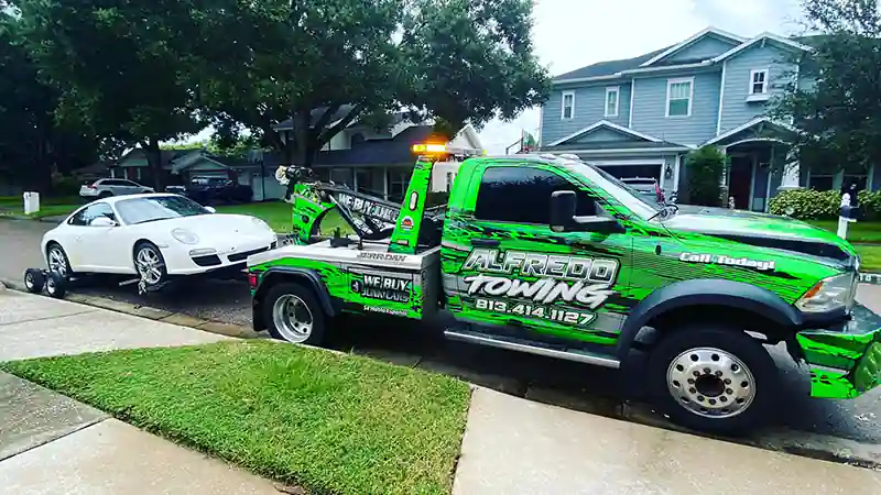 a pickup truck with a car executing a light duty towing service