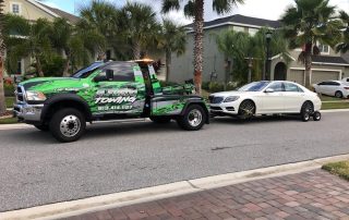 A Pick up Truck towing a white Car.